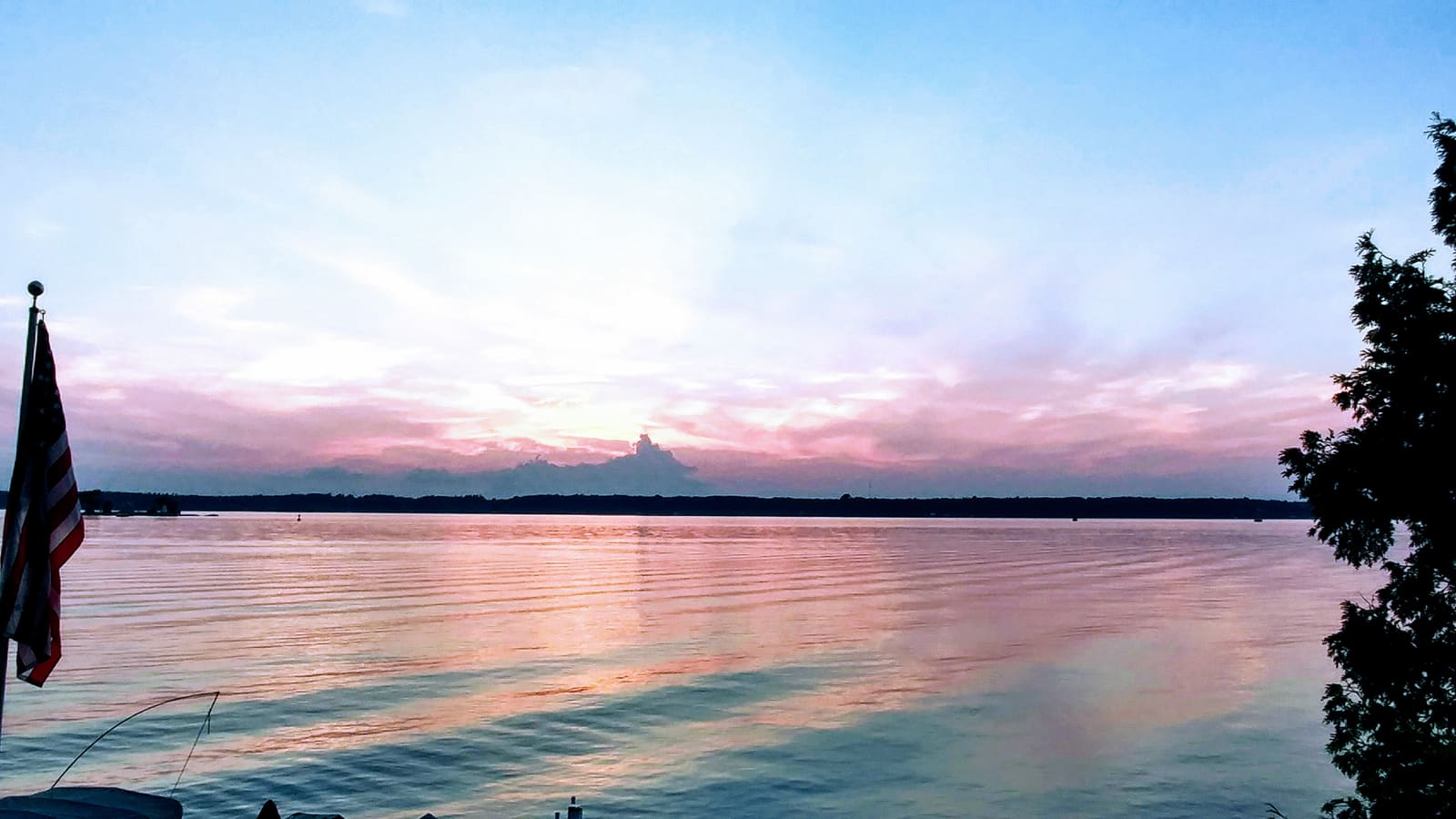 Soft pink sunset reflected across still water